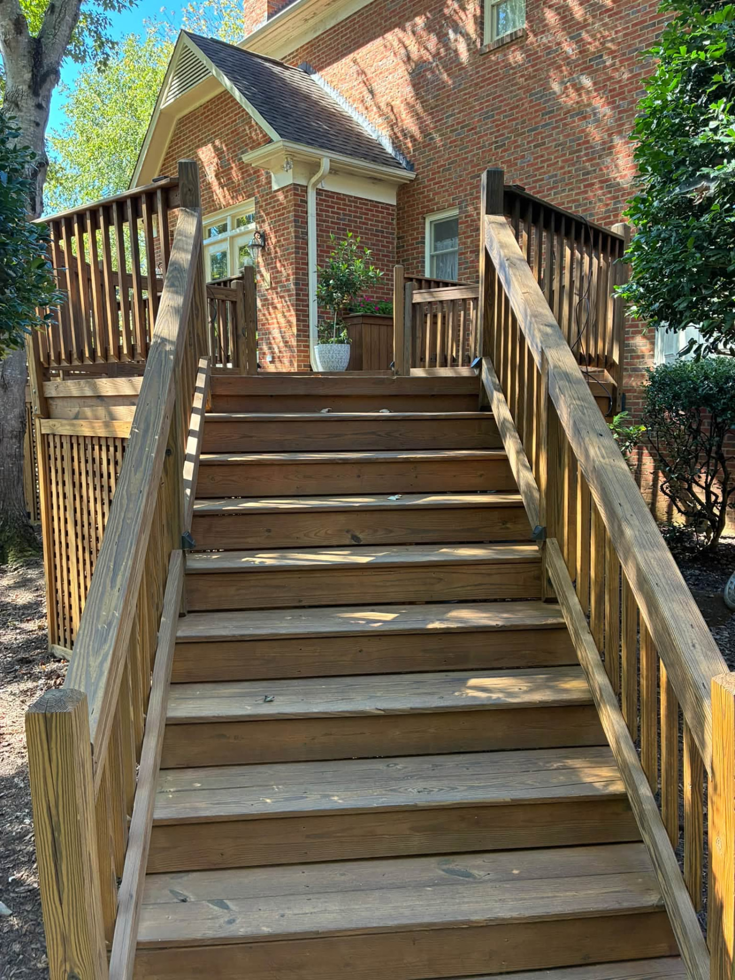 After: Deck stairs and railings — pressure washed, then stained. Same stairs, same day.